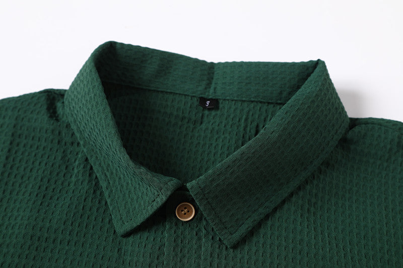 Polo con risvolto verde scuro e motivo a nido d'ape retrò - Una maglia casual a maniche corte con texture traspirante